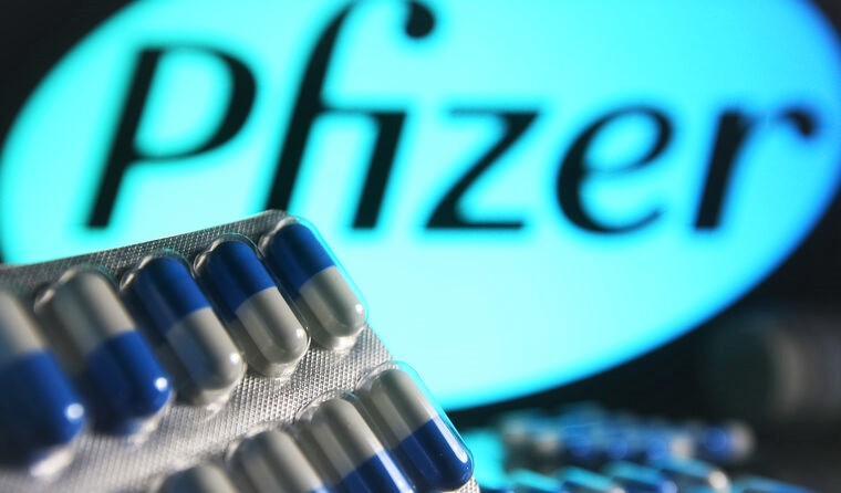 Pills in front of Pfizer logo