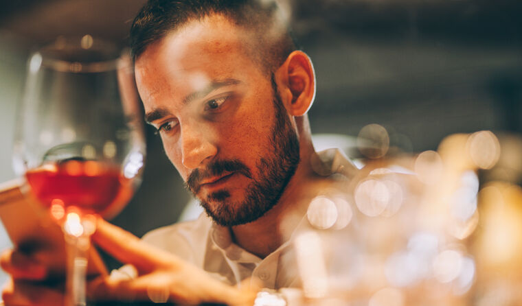 Man sitting in front of a wine glass.