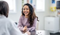 Laughing woman speaking to a doctor.