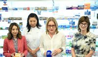 MPs and a pharmacist standing in a pharmacy.
