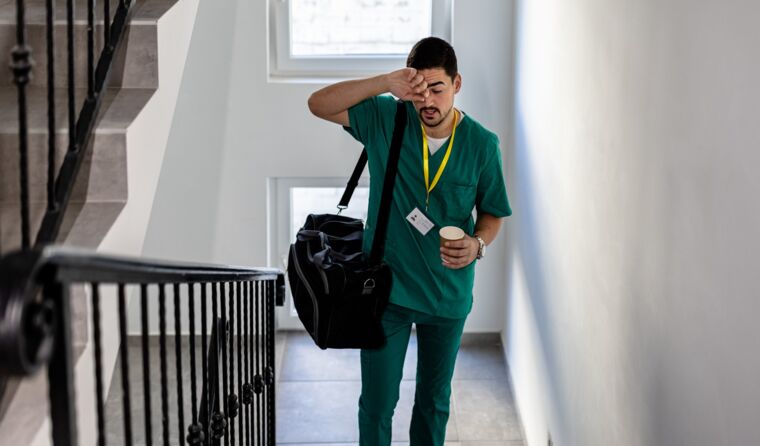 Tired medical student walking up stairs.