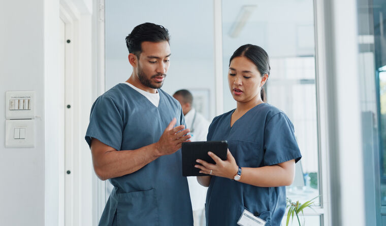 Young male and female nurse chat in a hospital.