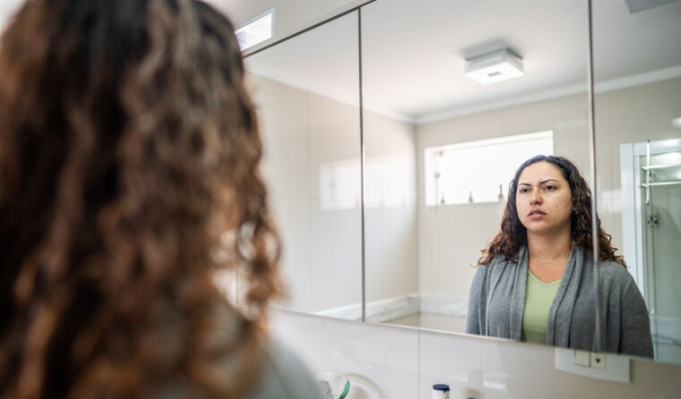 Woman looking at herself in the mirror.