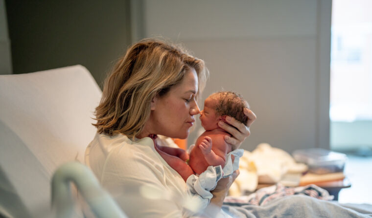 Woman holder her newborn baby in hospital.
