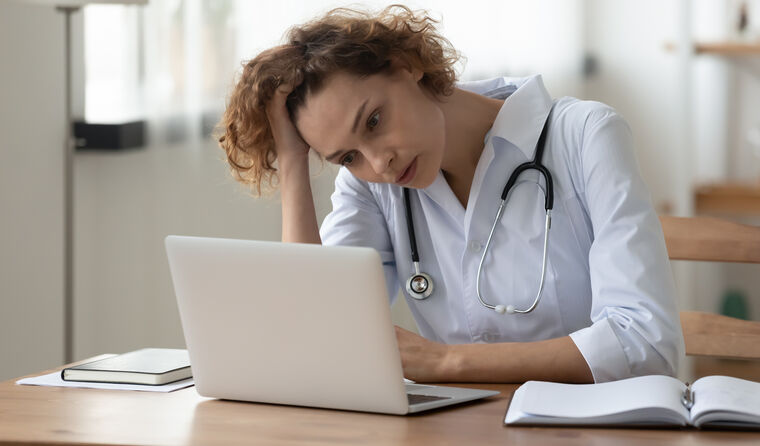 Stressed medical professional in front of a laptop