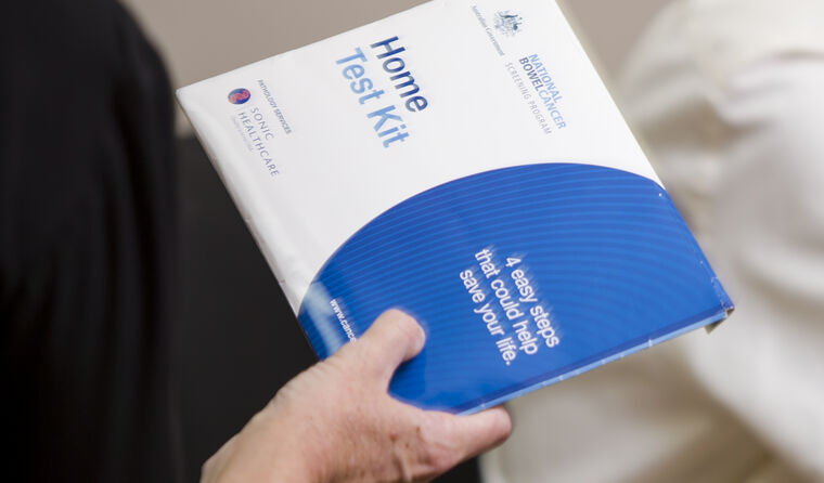 Patient holding bowel cancer screening kit