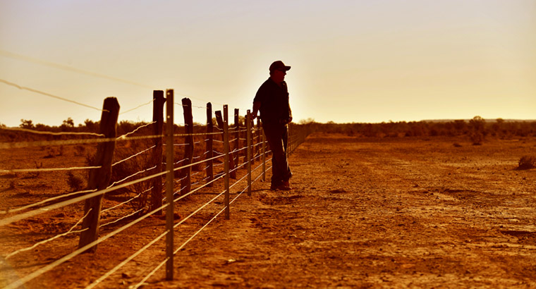 Man against fence in rural setting