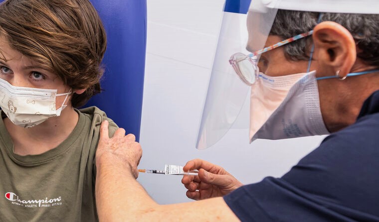 Young boy receiving Pfizer vaccine.