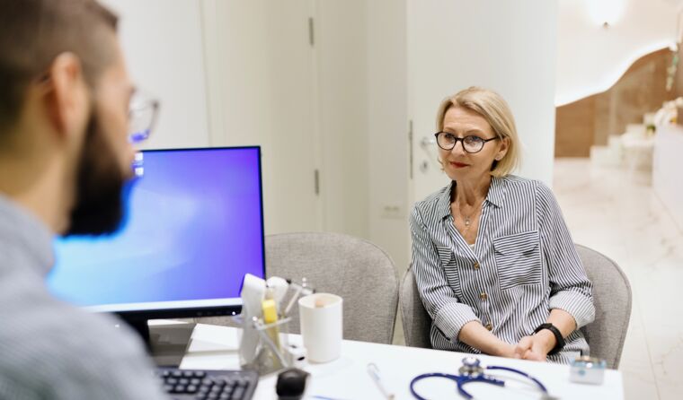Female patient in consult, with computer visible