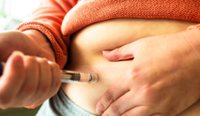 A person injecting a weight loss drug into belly.