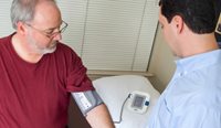 Overweight man receiving a blood pressure test.