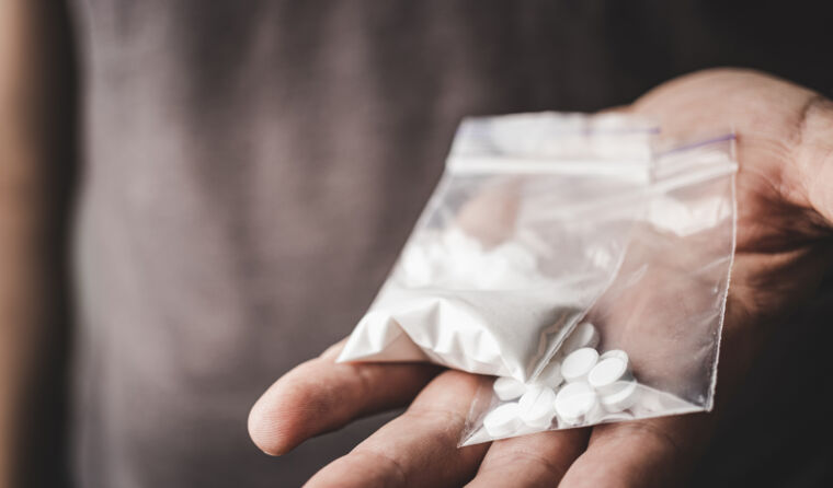 Close up of hands holding bags of stimulant drugs