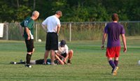 Football playing laying on field with concussion.