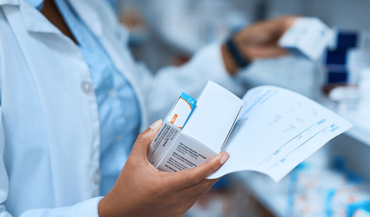 Pharmacist holding script and medicines