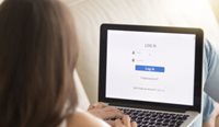 A woman sitting on the couch using a laptop. 