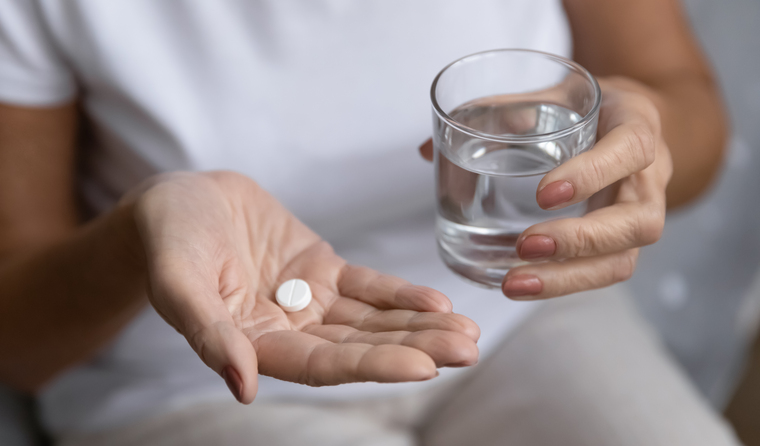 Woman taking aspirin pill