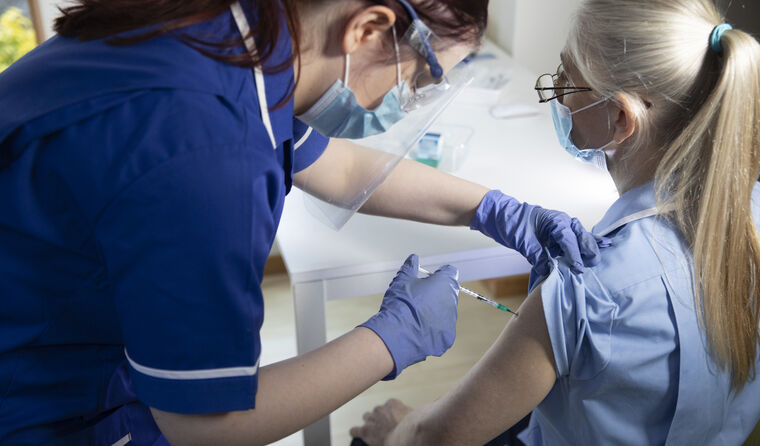 Nurse receiving a COVID vaccine.