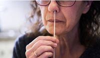 A women inserting a swab into her nose.