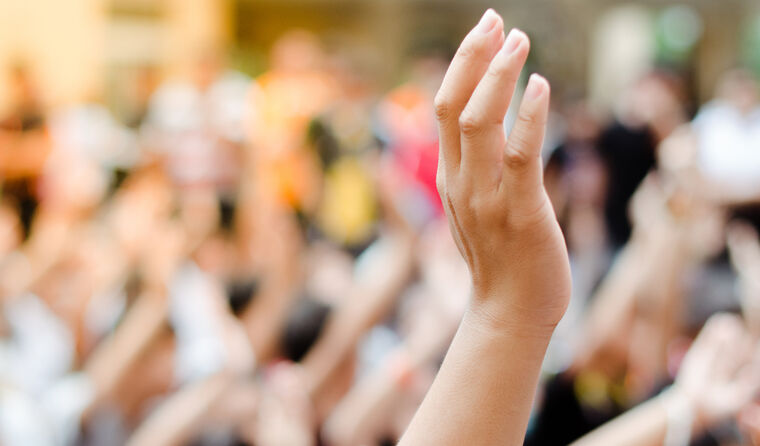 Group of people with hands up voting