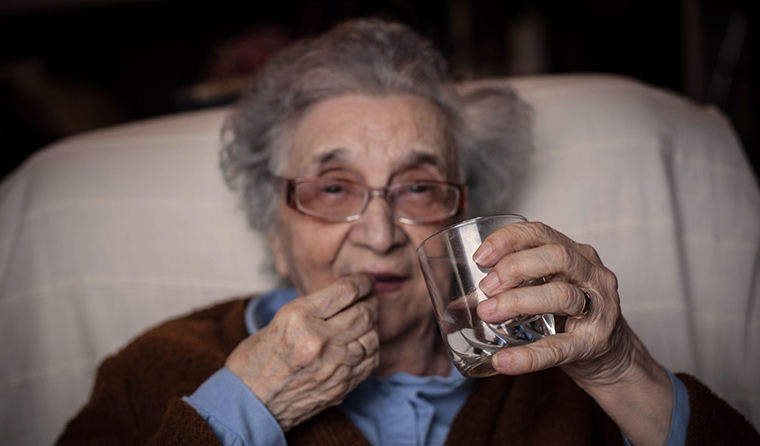 Elderly woman taking aspirin