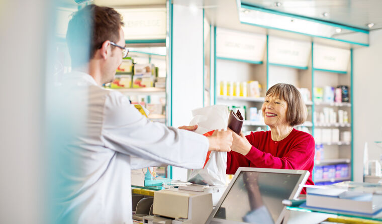 Woman paying for prescription at pharmacy.