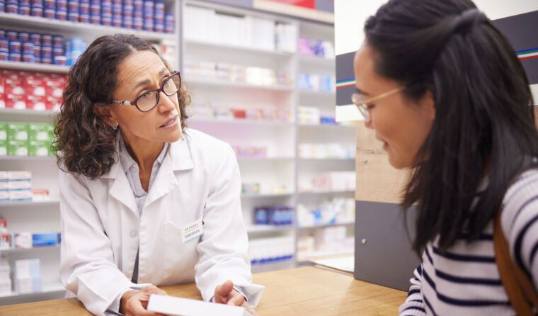 Female pharmacist speaks with female customer