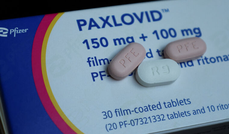 Three Paxlovid tablet sitting on box.