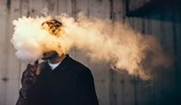 Person vaping whose head is covered by vapour