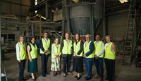 Group of people standing at a recycling plant.