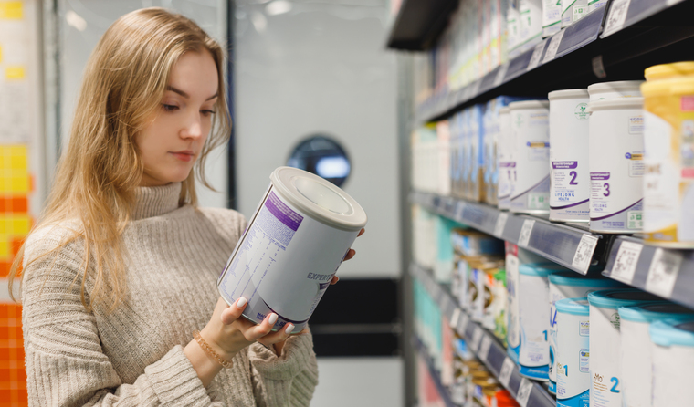 Woman looking at baby formula in shop