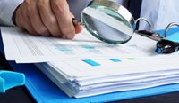 Person closely examining financial documents.