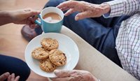 Older person with tea and biscuits
