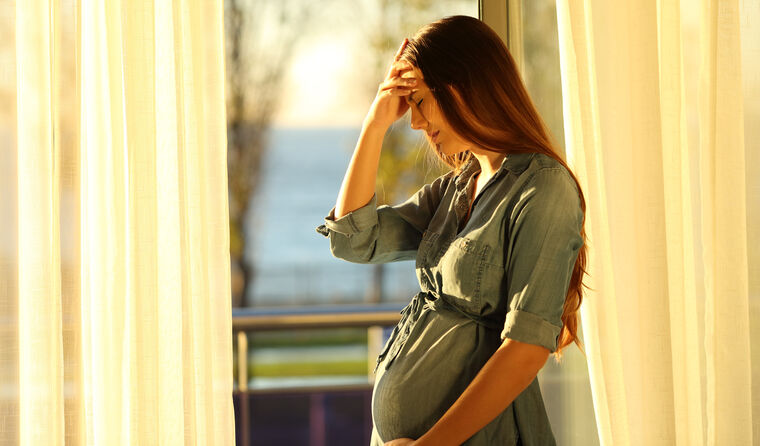 Pregnant woman looking stressed.