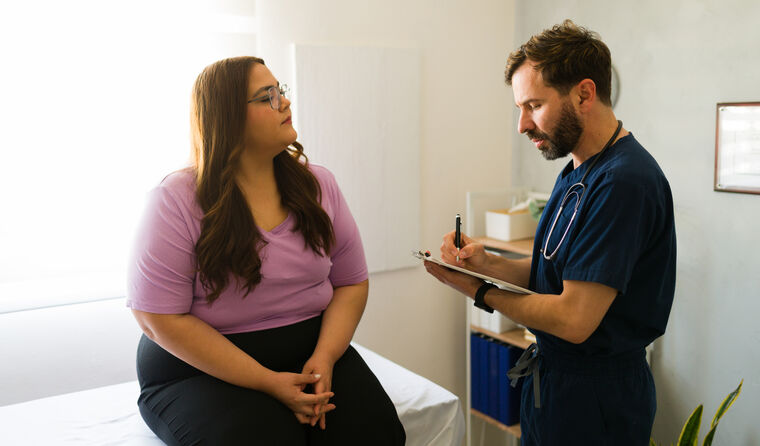 GP talking to overweight patient