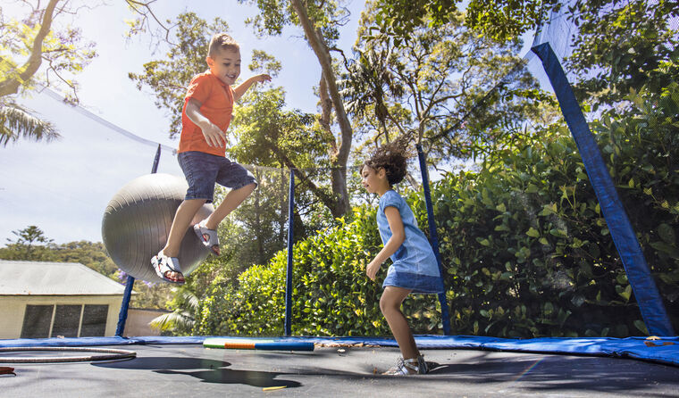 Young children bouncing on trampoline