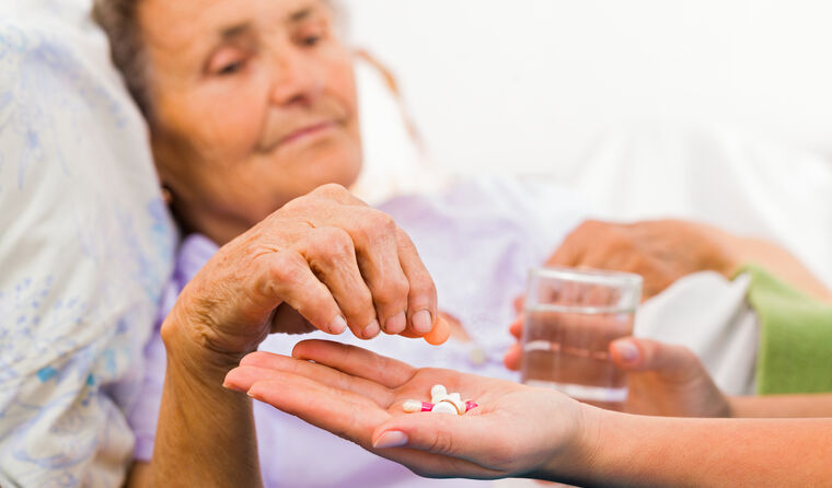 Elderly person being given medication.