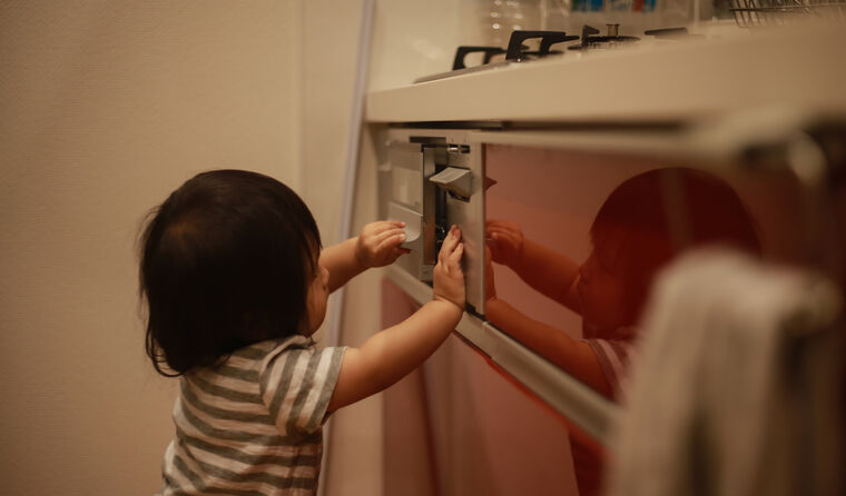 Young child playing with gas oven.
