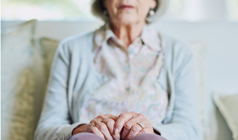 Elderly woman sitting on a couch.