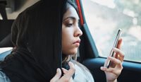 Young Muslim woman looking serious at phone