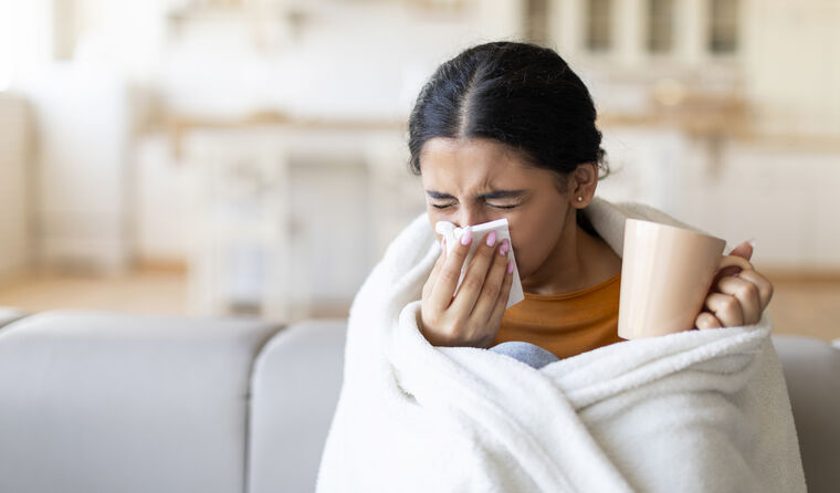 A patient blowing his nose on the sofa.