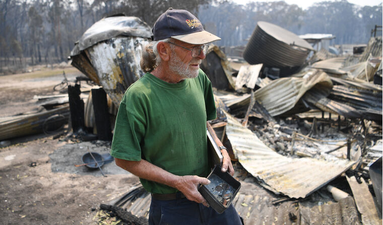 Man surveying his burnt out property.