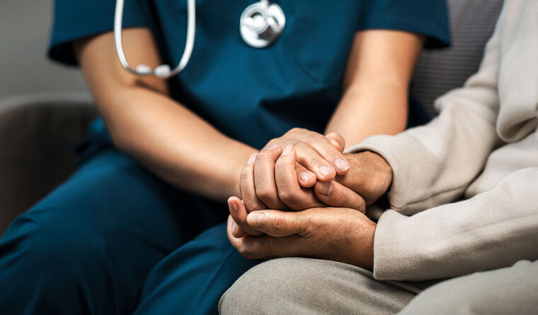GP holding a patient's hand.