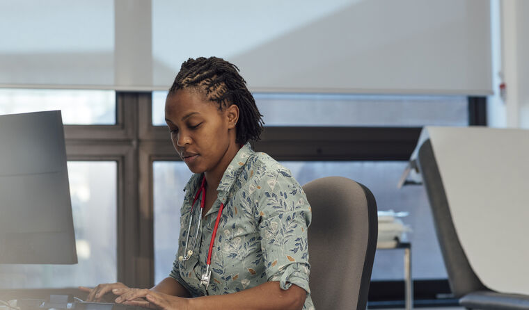 Female GP looking at computer for referral advice