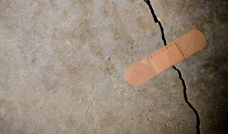Bandaid stuck onto cracked concrete.