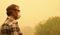 Man wearing mask amid bushfire smoke.