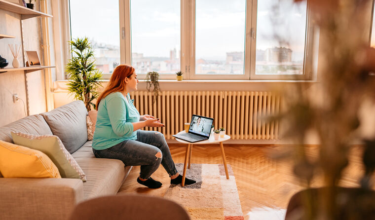Woman at home doing telehealth consult on laptop