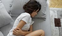 Woman holding stomach in pain.