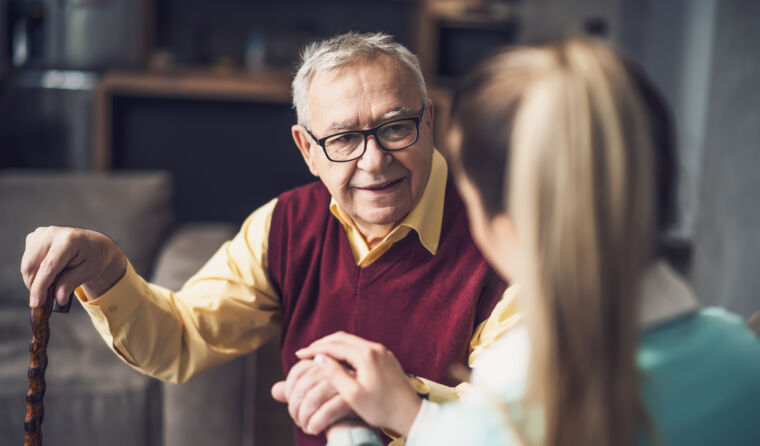 Woman holding older man's hand.