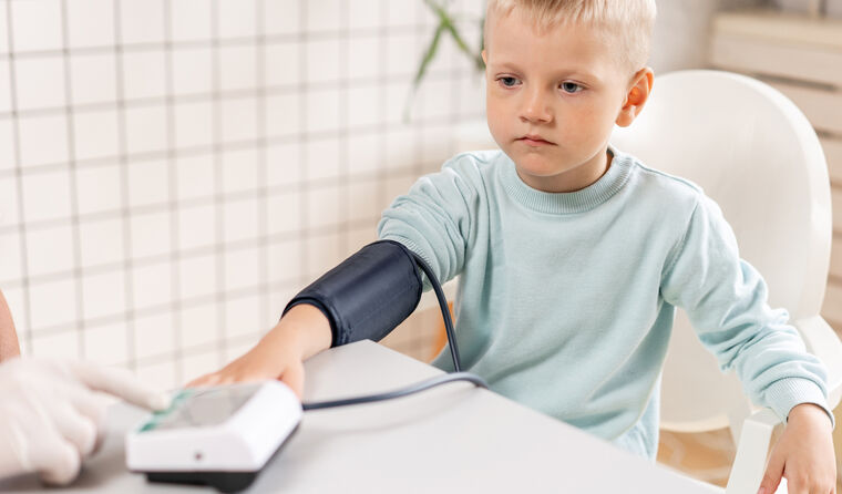 Primary school boy having blood pressure check
