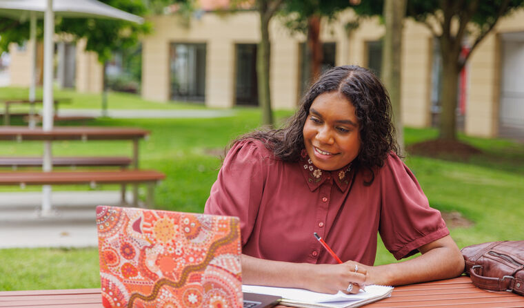Female Aboriginal student at laptop on campus